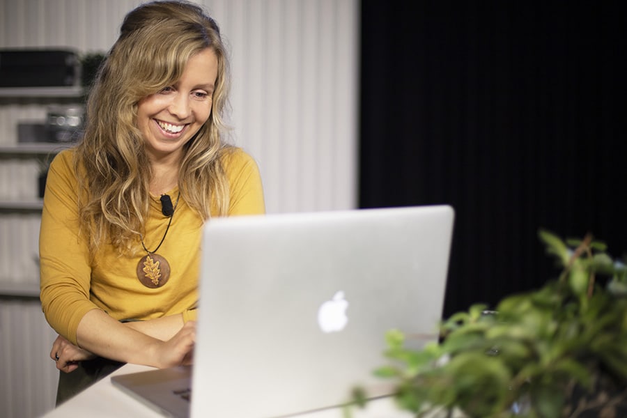 Maria Lindberg sitter med en Macbook i Moderskeppets studio.