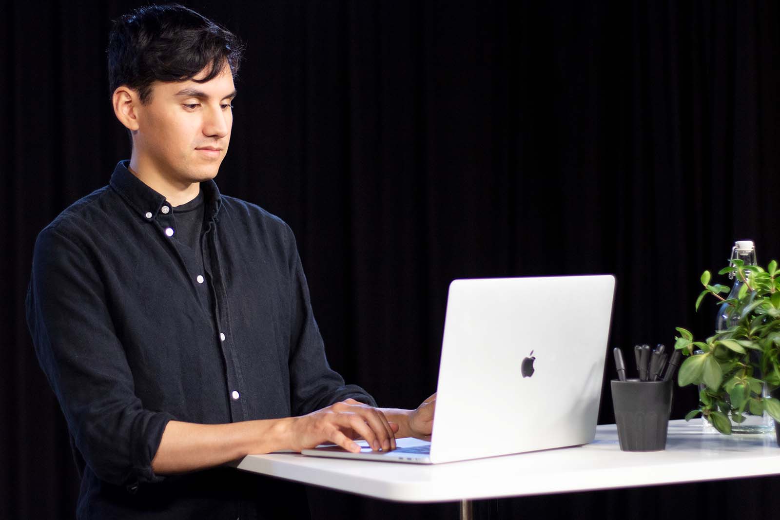 Stefan Cautin står och jobbar vid en laptop.